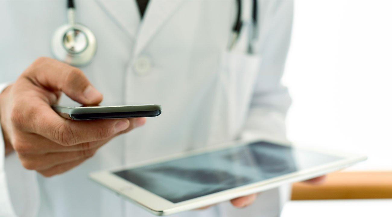 Doctor using healthcare app on ipad and mobile phone