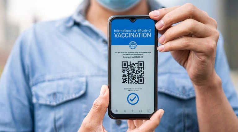 Man holding mobile phone displaying Covid Vaccine App
