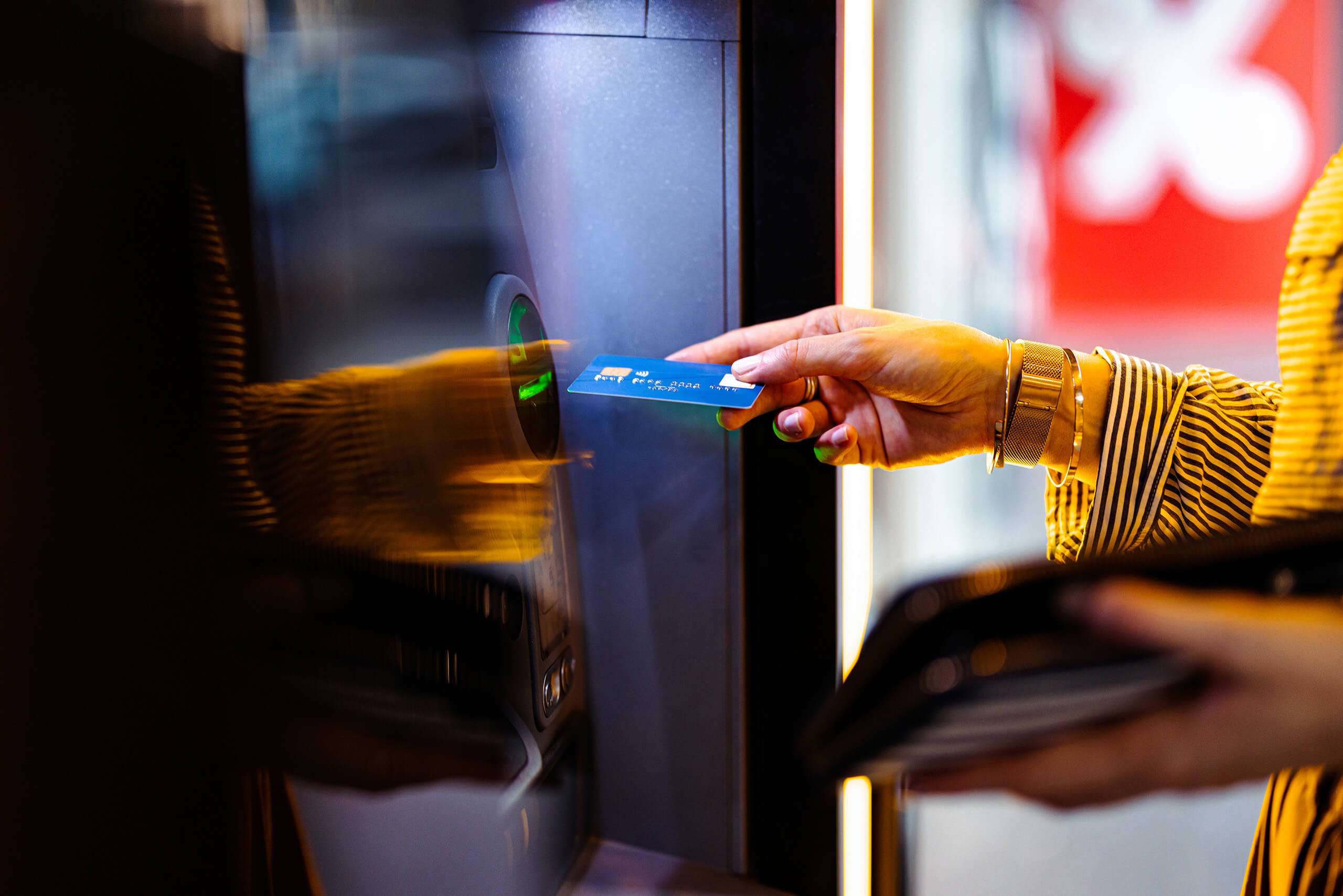 Close up photo of woman hands putting credit card To ATM machine