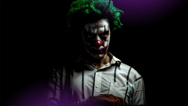 A man dressed in Joker makeup and wearing a pinstriped shirt.