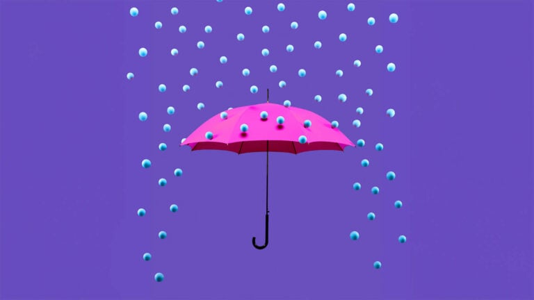 Des boules bleues ressemblant à des perles pleuvent sur un parapluie ouvert.